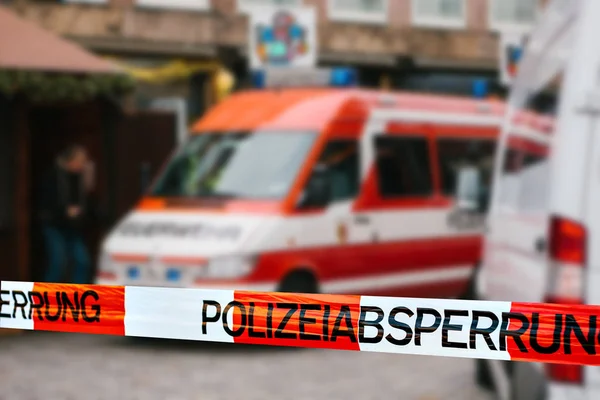 Polizeiband in Deutschland am Tatort mit der Aufschrift "Polizeiabsperrung". Feuerwehrauto im Hintergrund. Polizeiband im Fokus. — Stockfoto