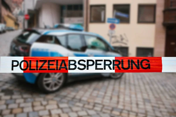 Olay yerinde polis teyp. Polis teyp, bir polis arabasının arka plan bulanık üzerinde odaklanmaktadır. Alman polisi.