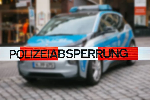 Olay yerinde polis teyp. Polis teyp, bir polis arabasının arka plan bulanık üzerinde odaklanmaktadır. Alman polisi.