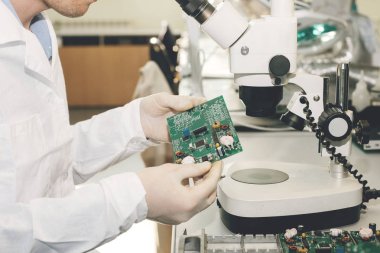 Teknisyen cips ile bir bilgisayar kurulu alır. Yedek parçalar ve bileşenler bilgisayar donanımları için. Elektronik ve bakım imalatı. Yüksek teknoloji ve robot kavramı.