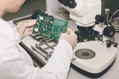 Teknisyen cips ile bir bilgisayar kurulu alır. Yedek parçalar ve bileşenler bilgisayar donanımları için. Elektronik ve bakım imalatı. Yüksek teknoloji ve robot kavramı.