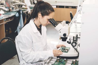 Güzel kadın bilgisayar uzman profesyonel teknisyen tahta bilgisayar bir fabrikada bir laboratuvarda inceleniyor. Sorun giderme. Teknik destek. Mühendislik. Üretim.