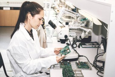 Güzel kadın bilgisayar uzman profesyonel teknisyen tahta bilgisayar bir fabrikada bir laboratuvarda inceleniyor. Sorun giderme. Teknik destek. Mühendislik. Üretim.