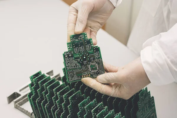 O técnico leva uma placa de computador com chips. Peças de reposição e componentes para equipamentos de informática. Produção de eletrônicos e manutenção. O conceito de alta tecnologia e robótica . — Fotografia de Stock