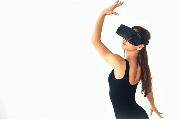 Deporte Chica atleta con una hermosa figura bailando con gafas de realidad virtual sobre un fondo blanco. Concepto de tecnología futura. Tecnología de imagen moderna . —  Fotos de Stock