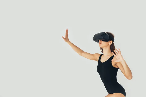 Deportiva atleta chica con una hermosa figura con gafas de realidad virtual. Concepto de tecnología futura. Tecnología de imagen moderna. Imagen conceptual de los deportes virtuales. Simulador deportivo . —  Fotos de Stock