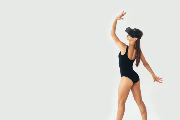 Sport athlete girl with a beautiful figure dancing with glasses of virtual reality. Future technology concept. Modern imaging technology. Conceptual image of a virtual dance and other sports. — Stock Photo, Image