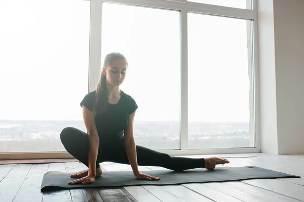 Jonge mooie vrouw die yoga en gymnastiek beoefent. Wellnessconcept. Klassen in één sport. — Stockfoto