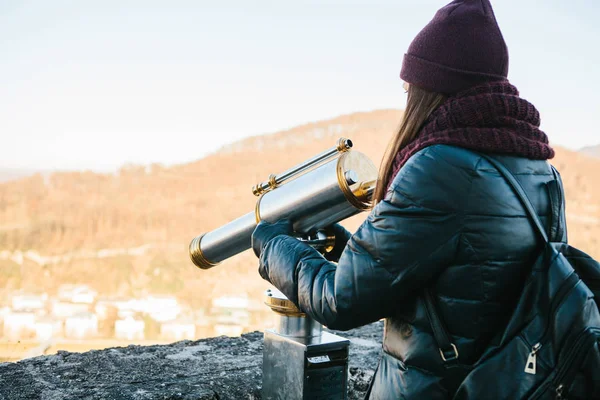 Young girl looks through the viewing binoculars on the lookout on the hill in the Austrian city of Salzburg - hometown of Mozart. — Stock Photo, Image