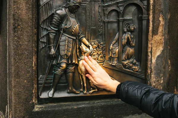 女性観光幸運のカレル橋のネポムクのヨハネの銅像に触れます。伝説。プラハ, チェコ共和国 — ストック写真