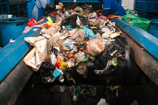 Workers sorted out the waste received by the modern plant for sorting and recycling waste. Waste processing plant. Technological process. Recycling and storage of waste for further disposal.