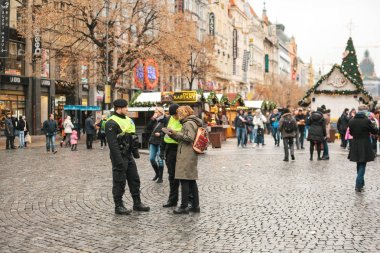 Prag, Çek Cumhuriyeti - 25 Aralık 2016: Bir Noel günü çek polis konumlar istediğiniz yere haritasında göster: turizm - yardım. Dairelerinden gelen turistler için saygılı tutum
