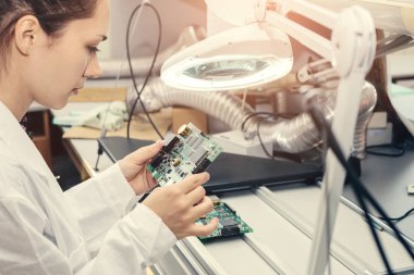 Güzel kadın bilgisayar uzman profesyonel teknisyen tahta bilgisayar bir fabrikada bir laboratuvarda inceleniyor. Sorun giderme. Teknik destek. Mühendislik. Üretim.