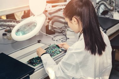 Güzel kadın bilgisayar uzman profesyonel teknisyen tahta bilgisayar bir fabrikada bir laboratuvarda inceleniyor. Sorun giderme. Teknik destek. Mühendislik. Üretim.