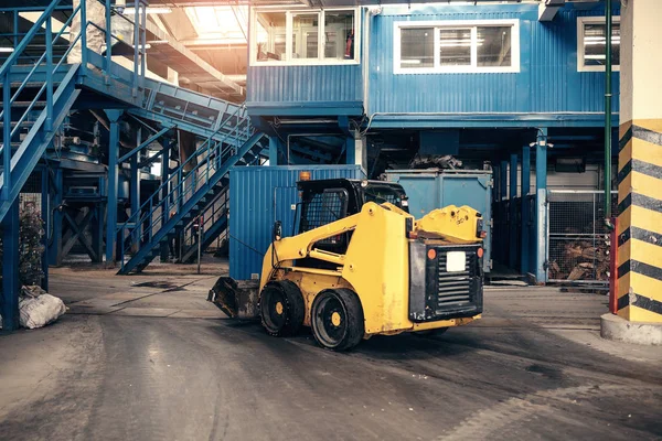 Una máquina industrial está conduciendo a través de la planta. Planta de tratamiento de residuos. Reciclaje y almacenamiento de residuos para su posterior eliminación. Negocio de clasificación y tratamiento de residuos . —  Fotos de Stock