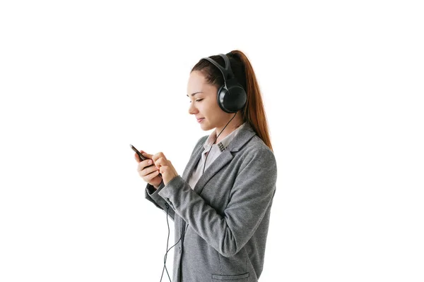 Menina bonita está ouvindo a música em um fundo branco — Fotografia de Stock