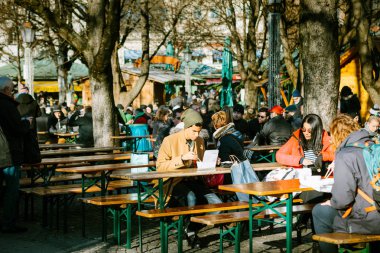 Münih, Almanya, 29 Aralık 2016: Genç bir adam sokak kahve lokanta ve Münih - Marienplatz Merkez Meydanı yakınındaki Ulusal Gıda yiyor. Avrupa'nın günlük yaşam.