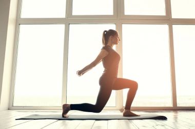 Yoga ve jimnastik yapan genç ve güzel bir kadın. Sağlık konsepti. Tek sporlu dersler.