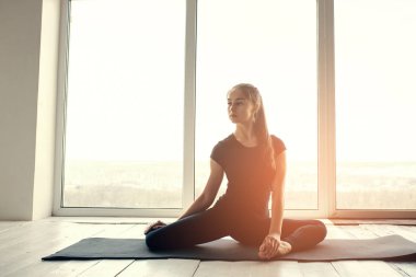 Yoga ve jimnastik yapan genç ve güzel bir kadın. Sağlık konsepti. Tek sporlu dersler.