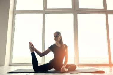 Yoga ve jimnastik yapan genç ve güzel bir kadın. Sağlık konsepti. Tek sporlu dersler.