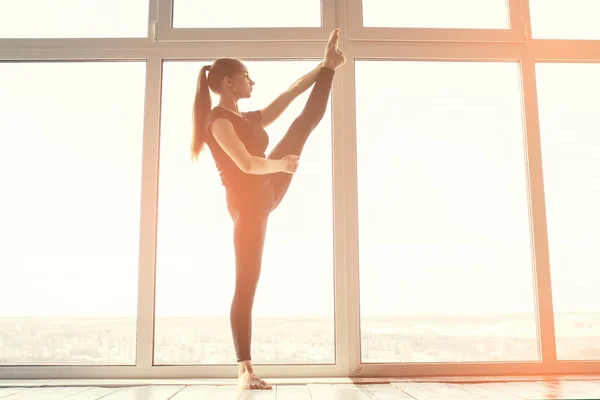 Jovem mulher bonita praticando ioga e ginástica. Conceito de bem-estar. Aulas de esportes individuais . — Fotografia de Stock