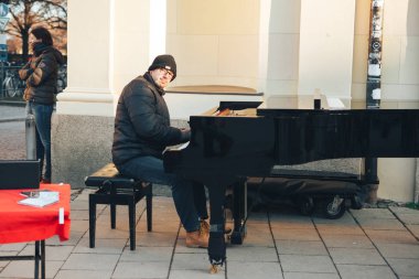 Münih, Almanya, 29 Aralık 2016: piyano bir sokak müzisyeni. Eğlence Avrupa'da turist. Sokak müzikal performans. Müzikal gösteri.