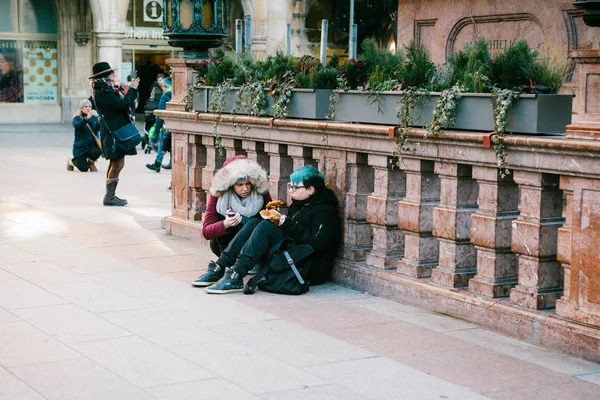 Monachium, Niemcy, zm. 29 grudnia 2016: Dwie dziewczyny punk usiąść i zjeść na centralnym placu w Monachium. Subkultura. Codzienne rutynowe życie w Europie. Bezdomnych, rebelianci. — Zdjęcie stockowe
