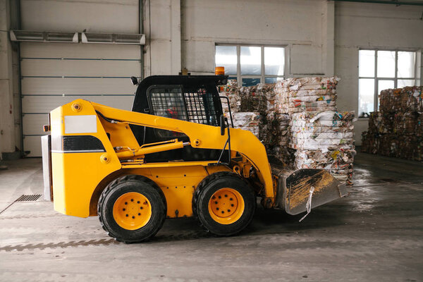 An industrial machine is driving through the plant. Waste processing plant. Recycling and storage of waste for further disposal. Business for sorting and processing of waste.