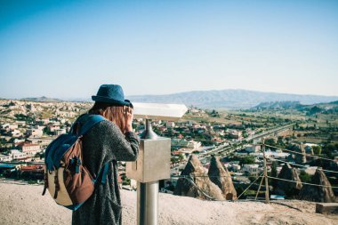 Bir gezgin, bakış açısı üzerinde bir sırt çantası ile dürbün, kasaba Göreme Kapadokya Türkiye'de güzel bir manzarasına bakar. Yolculuk. Hiking.