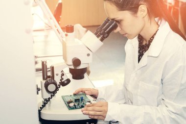 Güzel kadın bilgisayar uzman profesyonel teknisyen tahta bilgisayar bir fabrikada bir laboratuvarda inceleniyor. Sorun giderme. Teknik destek. Mühendislik. Üretim.