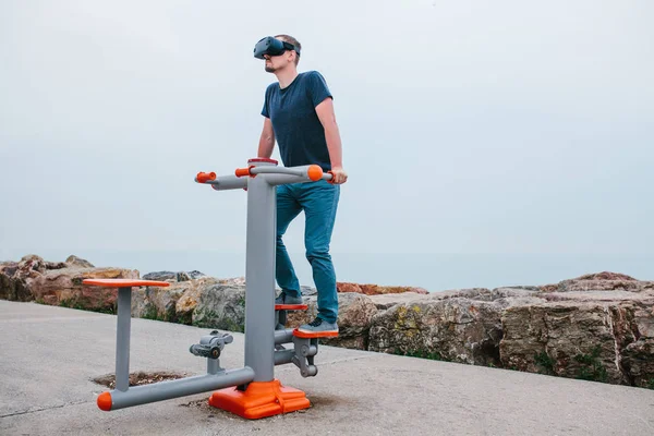 Un homme en lunettes de réalité virtuelle fait du sport. Concept technologique futur. Technologie d'imagerie moderne. Cours de sport individuel à distance . — Photo