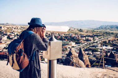 Bir gezgin, bakış açısı üzerinde bir sırt çantası ile dürbün, kasaba Göreme Kapadokya Türkiye'de güzel bir manzarasına bakar. Yolculuk. Hiking.