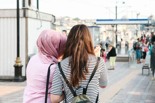 A European young girl does selfie on the phone with a local woman in Istanbul, Turkey. A photo for memory, friendship among people of different nationalities and religions. Travel. Street lifestyle. — Stock Photo, Image
