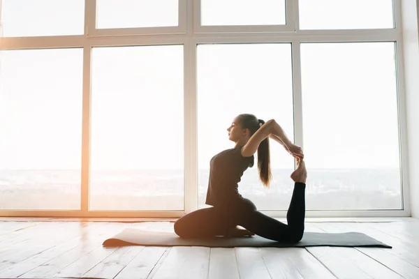 Jonge mooie vrouw die yoga en gymnastiek beoefent. Wellnessconcept. Klassen in één sport. — Stockfoto