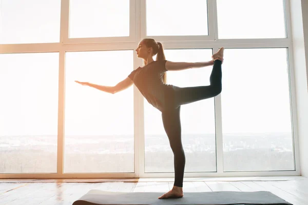 Fiatal, gyönyörű nő, aki jógázik és tornázik. Wellness koncepció. Egyedülálló sportórák. — Stock Fotó