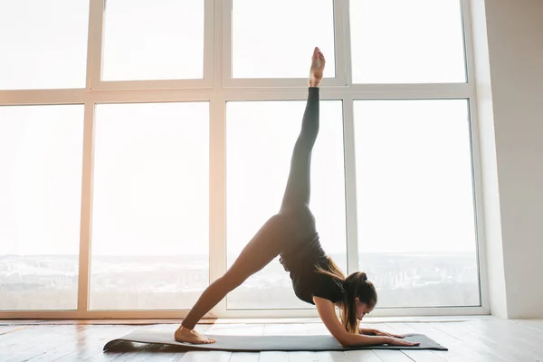 Giovane bella donna che pratica yoga e ginnastica. Concetto benessere. Lezioni in singolo sport . — Foto Stock