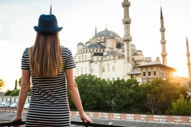Güzel bir rakam genç turist kızla dünya ünlü Sultanahmet Camii Sultanahmet Istanbul, Türkiye'de otel terasından görünüyor. Seyahat, gezi, dinlenme, dinlenme.