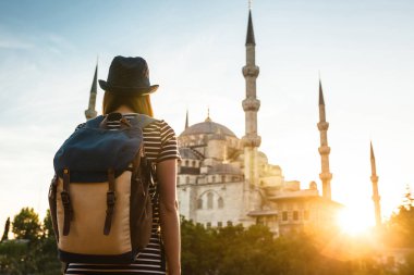 Genç güzel kız gezgin bir mavi Camii - Istanbul 'un ünlü bir turistik seyir bir sırt çantası ile şapkalı. Seyahat, turizm, gezi.