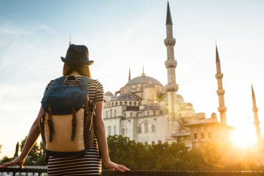 Genç güzel kız gezgin bir mavi Camii - Istanbul 'un ünlü bir turistik seyir bir sırt çantası ile şapkalı. Seyahat, turizm, gezi.