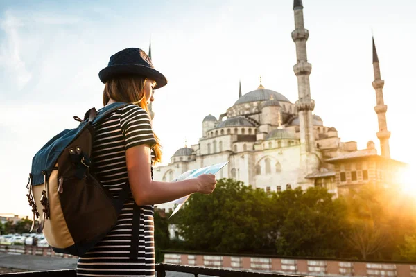 Mladé krásné cestovatel dívka v klobouku s batohem sleduje mapu vedle modré mešity - slavný pohled z Istanbulu. Cestování, Turistika, Památky. — Stock fotografie