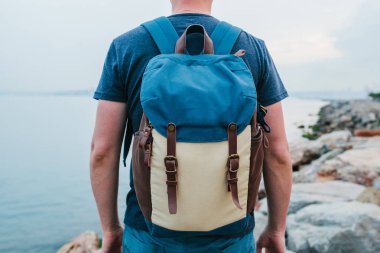 Deniz kenarı bir sırt çantası ile bir turist. Seyahat, turizm, rekreasyon.