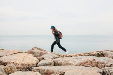Bir sırt çantası ile şapkalı bir gezgin deniz ile birlikte çalışır. Seyahat, dinlenme, hiking, özgürlük.