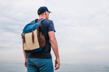 Deniz kenarı bir sırt çantası ile bir turist. Seyahat, turizm, rekreasyon.