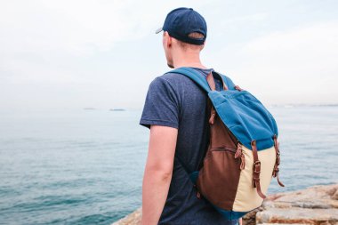 Deniz kenarı bir sırt çantası ile bir turist. Seyahat, turizm, rekreasyon.