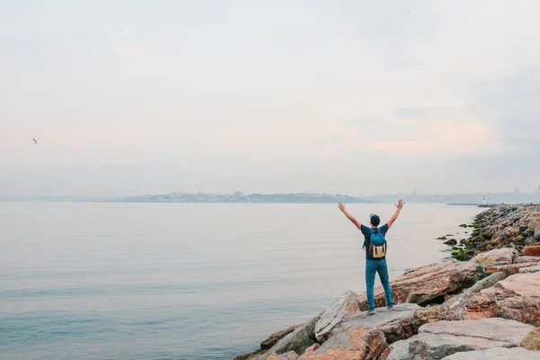 A tourist with a backpack on the coast. Travel, tourism, recreation.