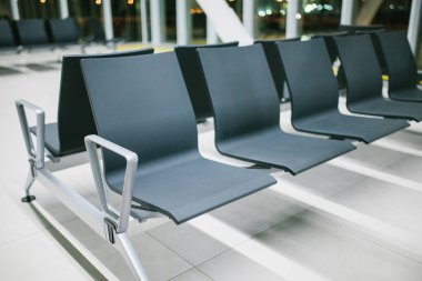 Havaalanında gece üst üste sandalyeyle boş bekleyen alanı. Gece uçuşu, transfer, havaalanında bekliyor. Kavramsal fotoğraf.