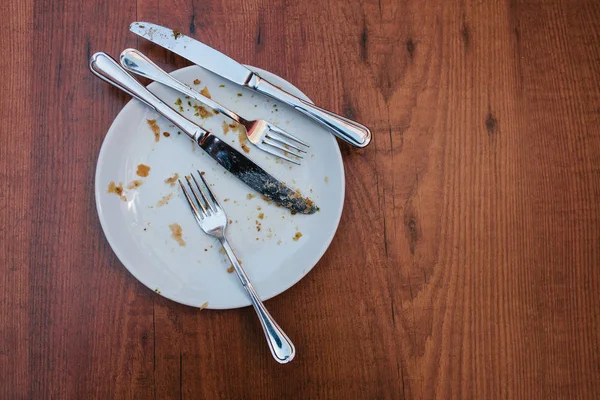 Dirty plate. Empty plate after eating place on wooden table in coffee shop. — Stock Photo, Image