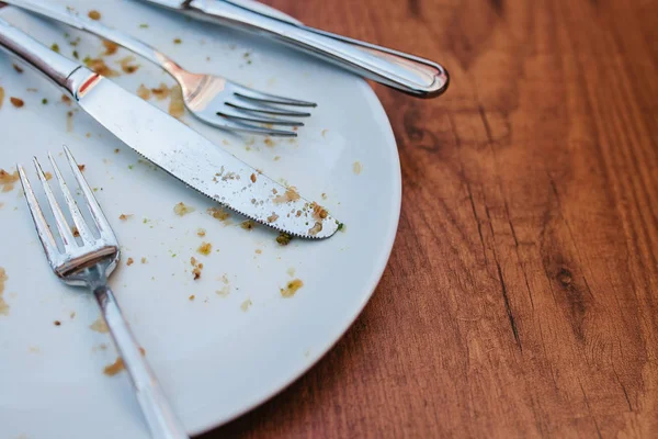 Dirty plate. Empty plate after eating place on wooden table in coffee shop. — Stock Photo, Image