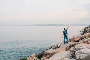 Deniz kenarı bir sırt çantası ile bir turist. Seyahat, turizm, rekreasyon.