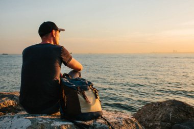 Deniz kenarı bir sırt çantası ile bir turist. Seyahat, turizm, rekreasyon. Sunset bulvarında.